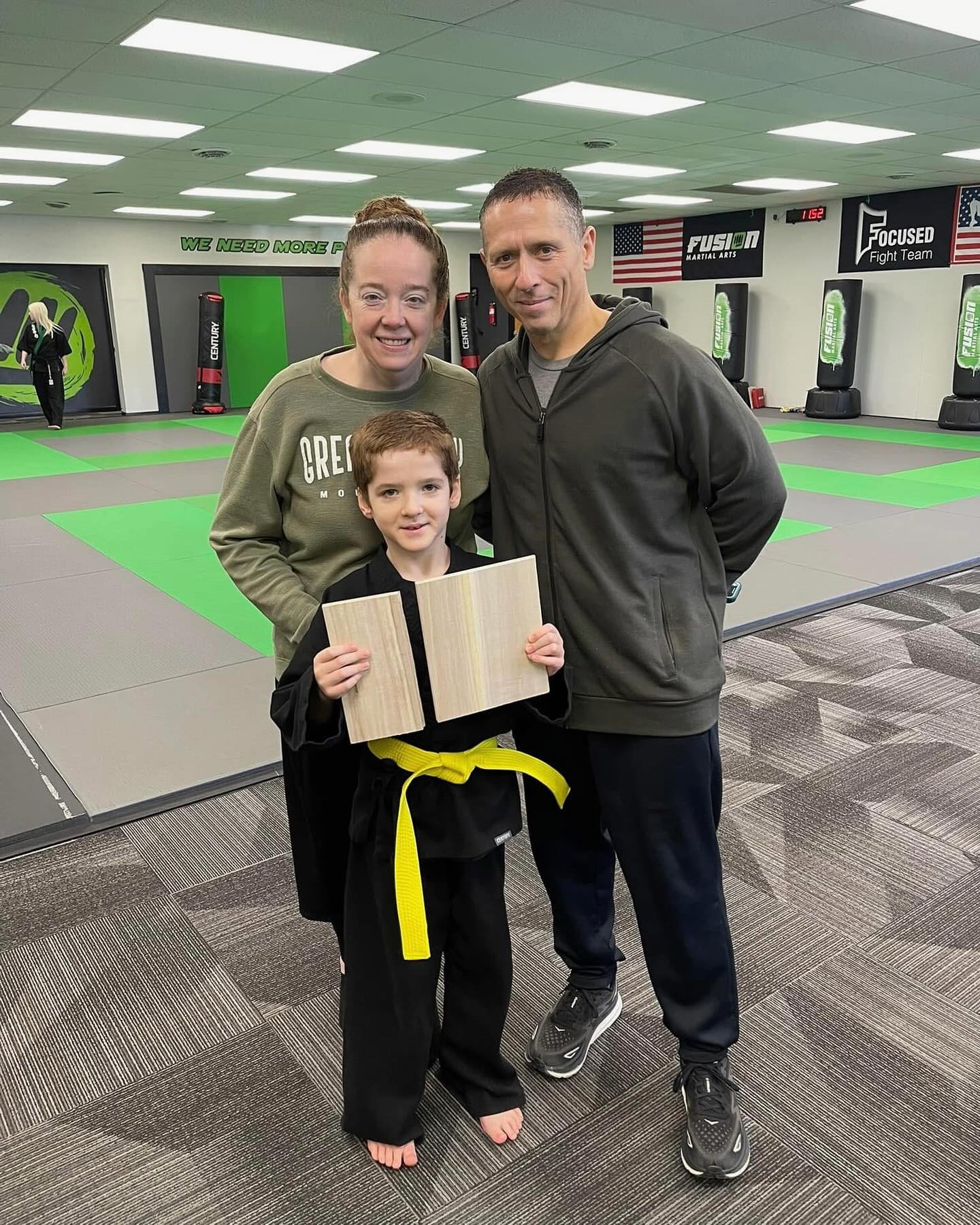 Student and family celebrating a belt promotion at Fusion Martial Arts