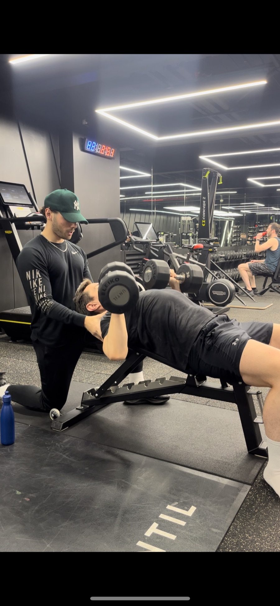 Joey Fox spotting a client on bench press