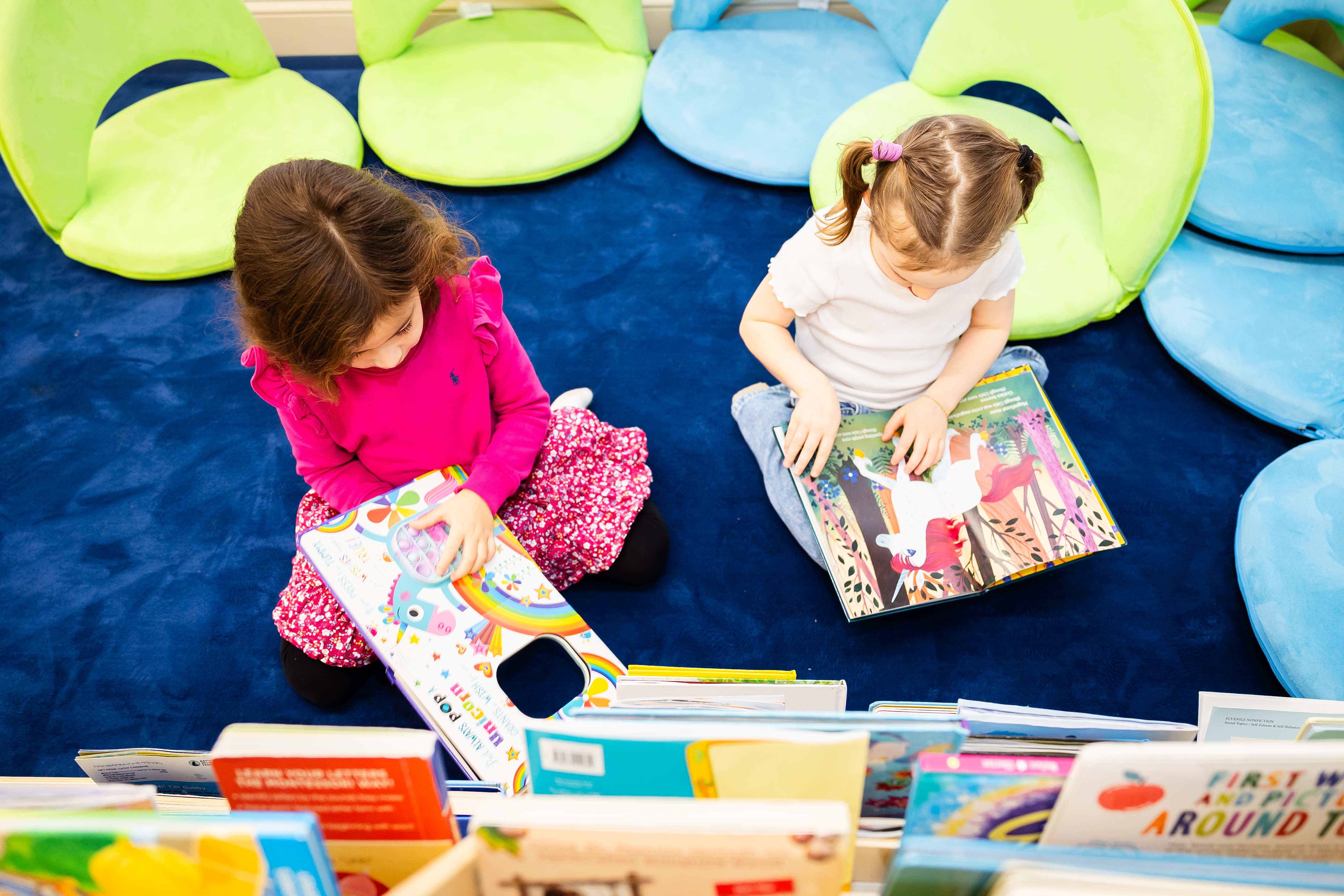 Two young students reading books independently in a screen-free learning environment at Apogee CT micro school in Connecticut.