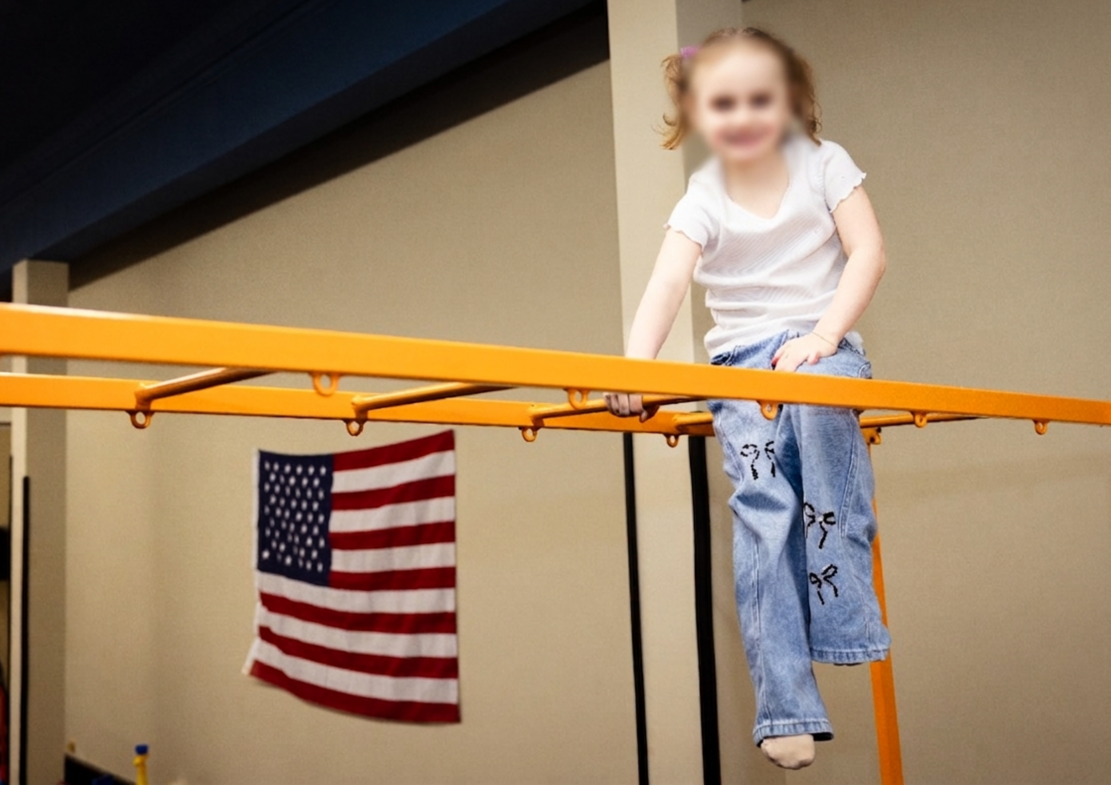 Young girl climbing monkey bars indoors, building confidence, strength, and independence through physical activity at a microschool Young girl climbing monkey bars indoors, building confidence, strength, and independence through physical activity at a microschool