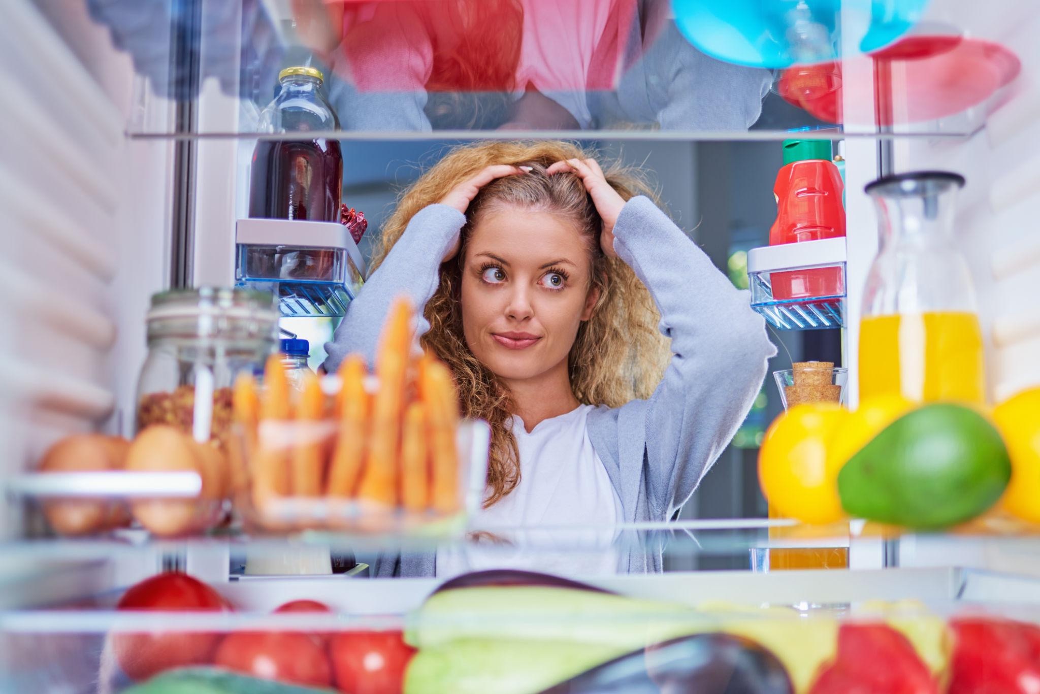 woman with cravings looking in the fridge