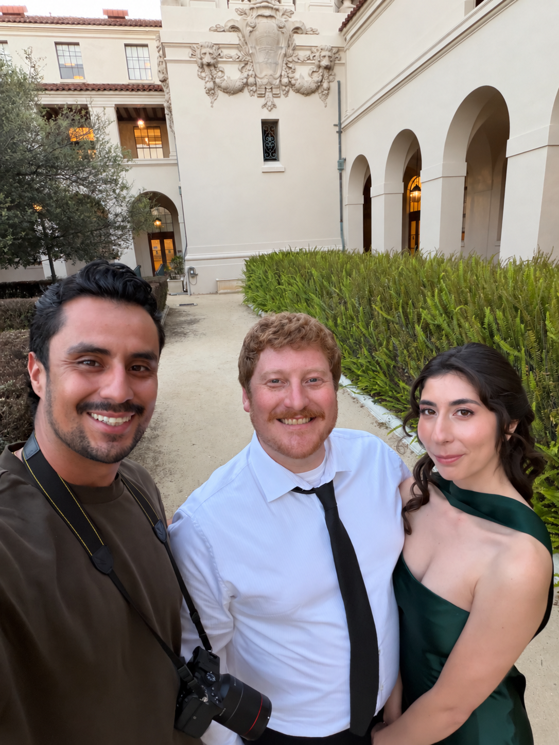 Aram with a couple outside a white building