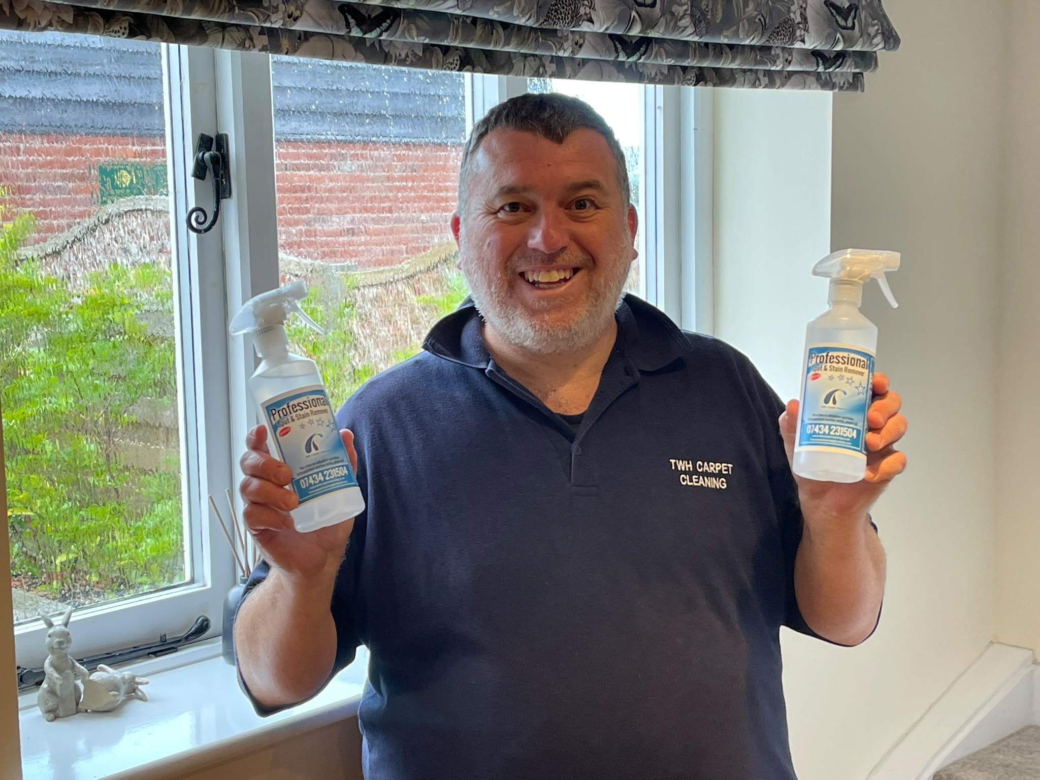 Tom from TWH Carpet Cleaning holding two bottles of Professional Spot & Stain Remover