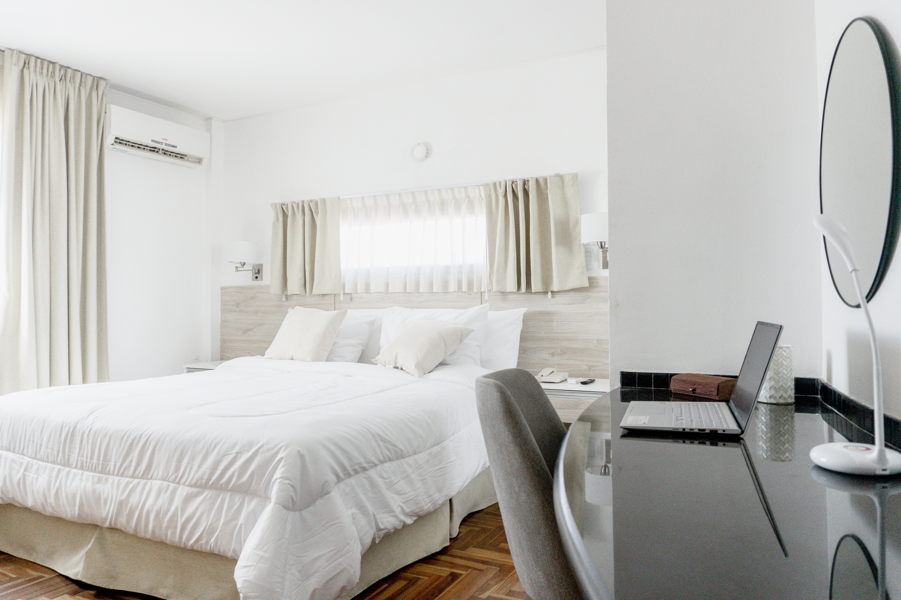 Habitación de Mediterráneo Hotel & Spa con cama doble, escritorio y ventanas con cortinas claras.