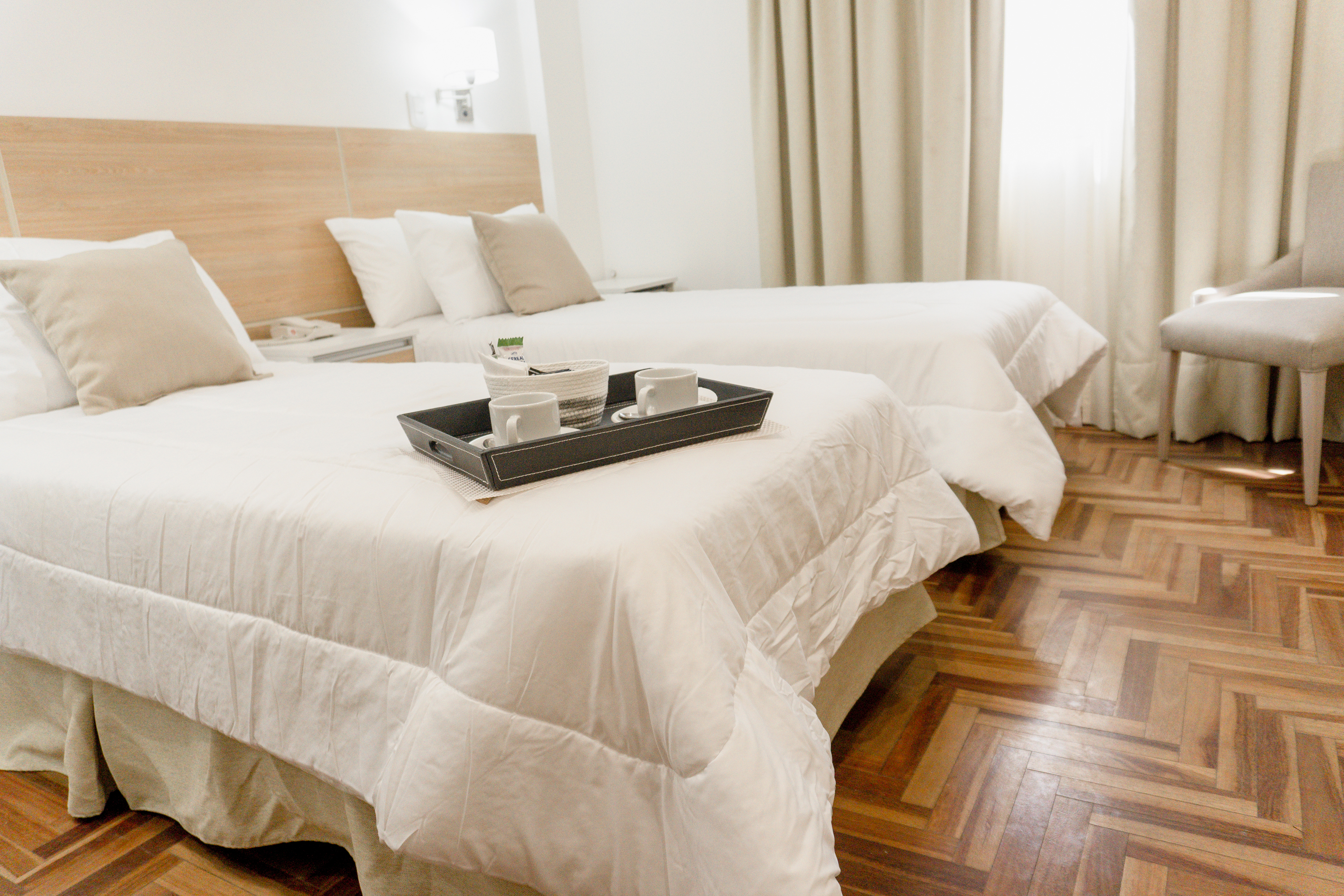 Habitación de Mediterráneo Hotel & Spa con dos camas y una bandeja de bienvenida con café.