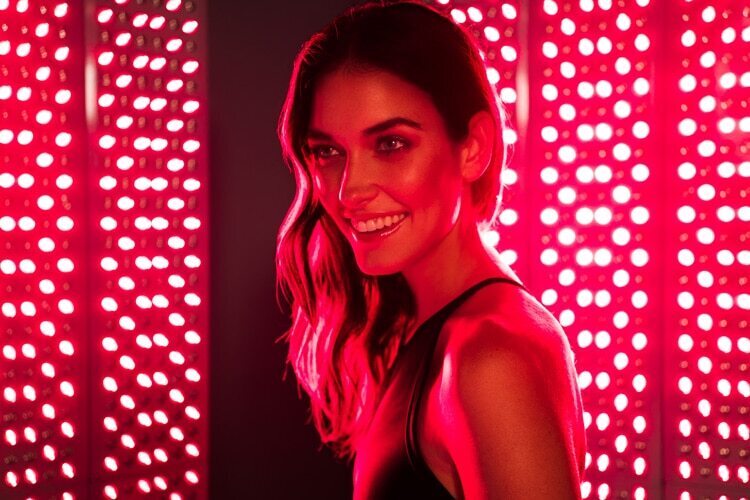 Client relaxing under full-body red light at ALBI Wellness