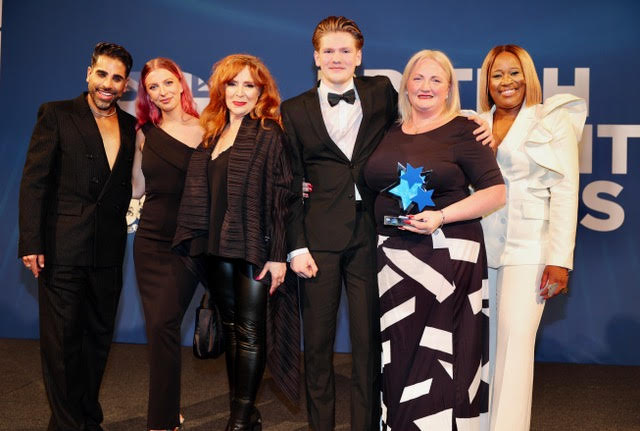 phillipa and her son charlie on stage being presented with her trophy by 4 celebrities