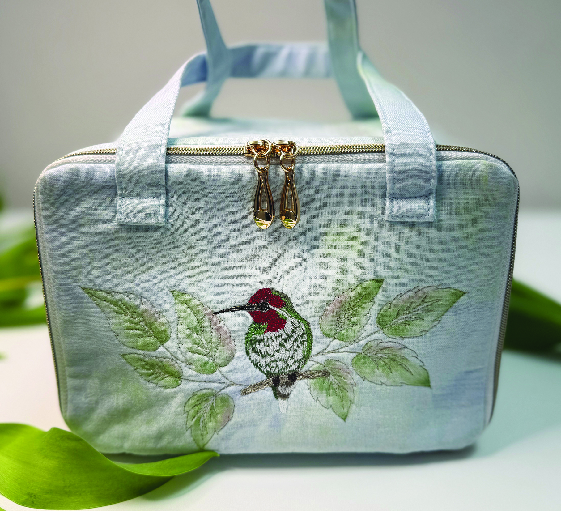 Hummingbirds and flowering fuchsias embroidered on a dark background