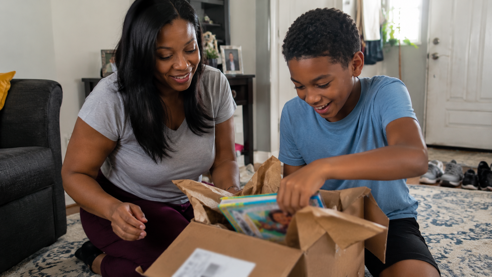 A mother and her son together on the living room floor, unboxing their Color History books