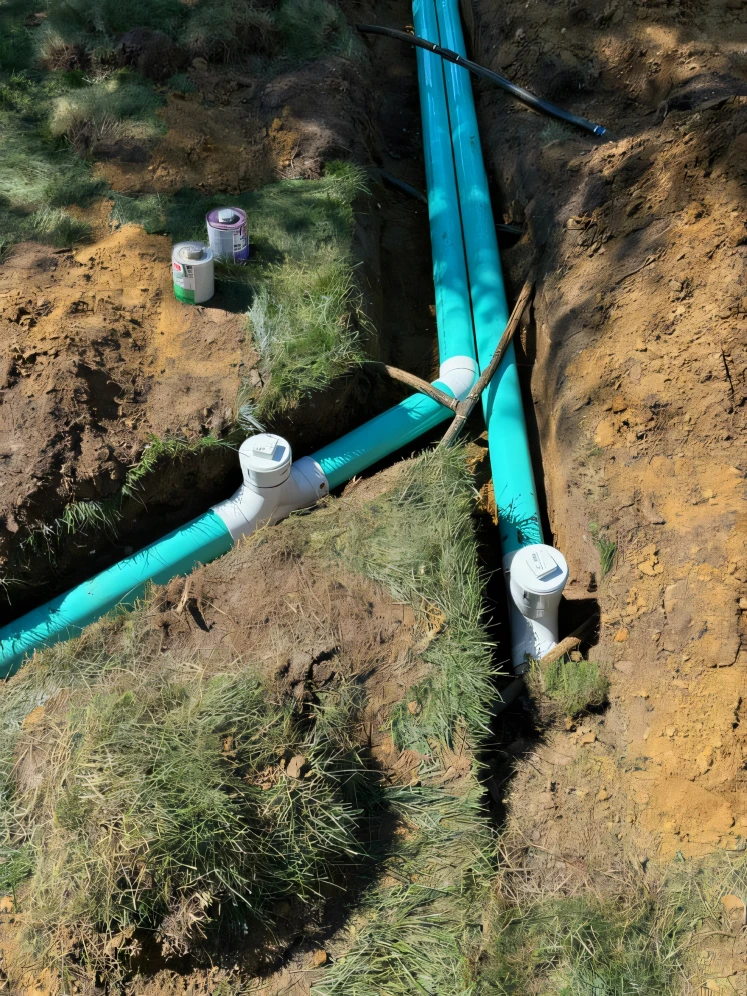 Multiple industrial pipes of varying sizes and materials running along the side of a building, illustrating complex plumbing infrastructure.