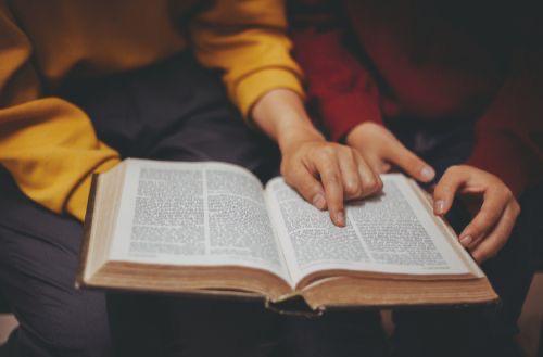 Close-up of a parent and child reading the Bible together at home during family devotions, symbolizing Christian parenting, spiritual growth, faith-based teaching, and building a Christ-centered family life.