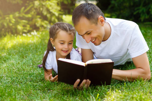 father and daughter reading the Bible outdoors