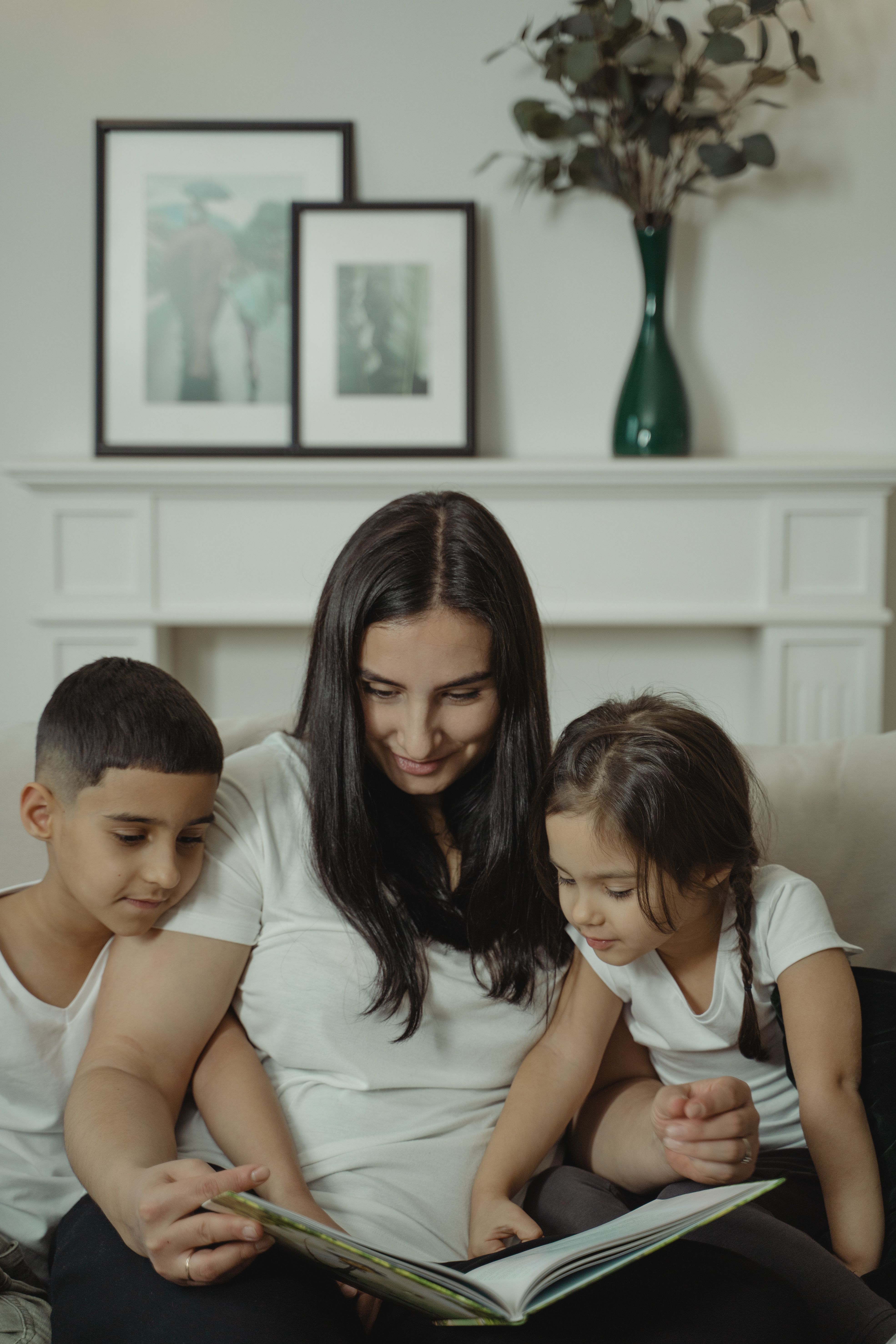 Mother reading a storybook with her young son and daughter on a couch, demonstrating quality family time, nurturing children's learning, Christian parenting, emotional bonding, and investing in children's character, faith, and lifelong development. Mother reading a storybook with her young son and daughter on a couch, demonstrating quality family time, nurturing children's learning, Christian parenting, emotional bonding, and investing in children's character, faith, and lifelong development.