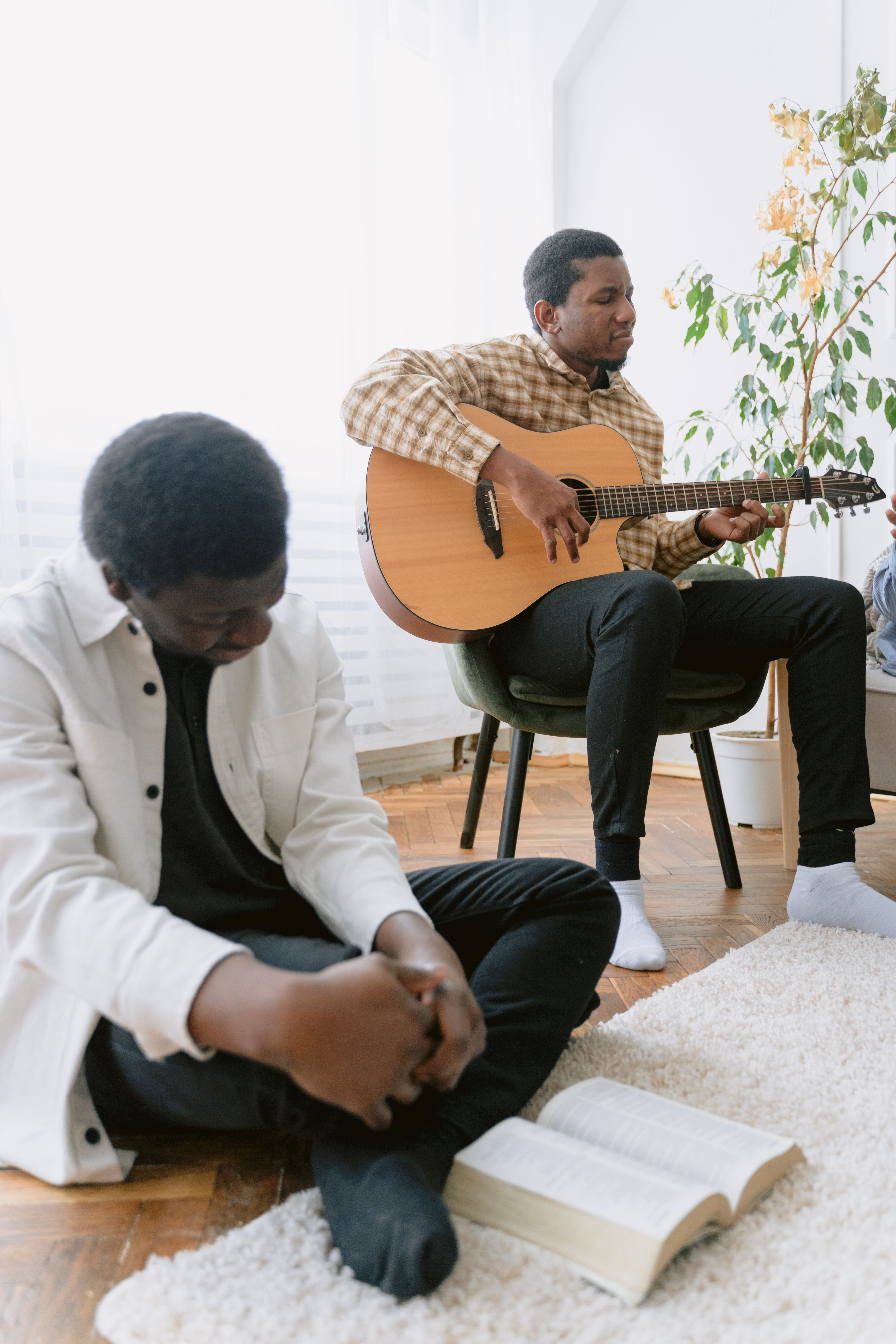 Family worship at home with a man playing guitar while loved ones pray and study the Bible, encouraging Christian faith, worship, and spiritual growth together. Family worship at home with a man playing guitar while loved ones pray and study the Bible, encouraging Christian faith, worship, and spiritual growth together.