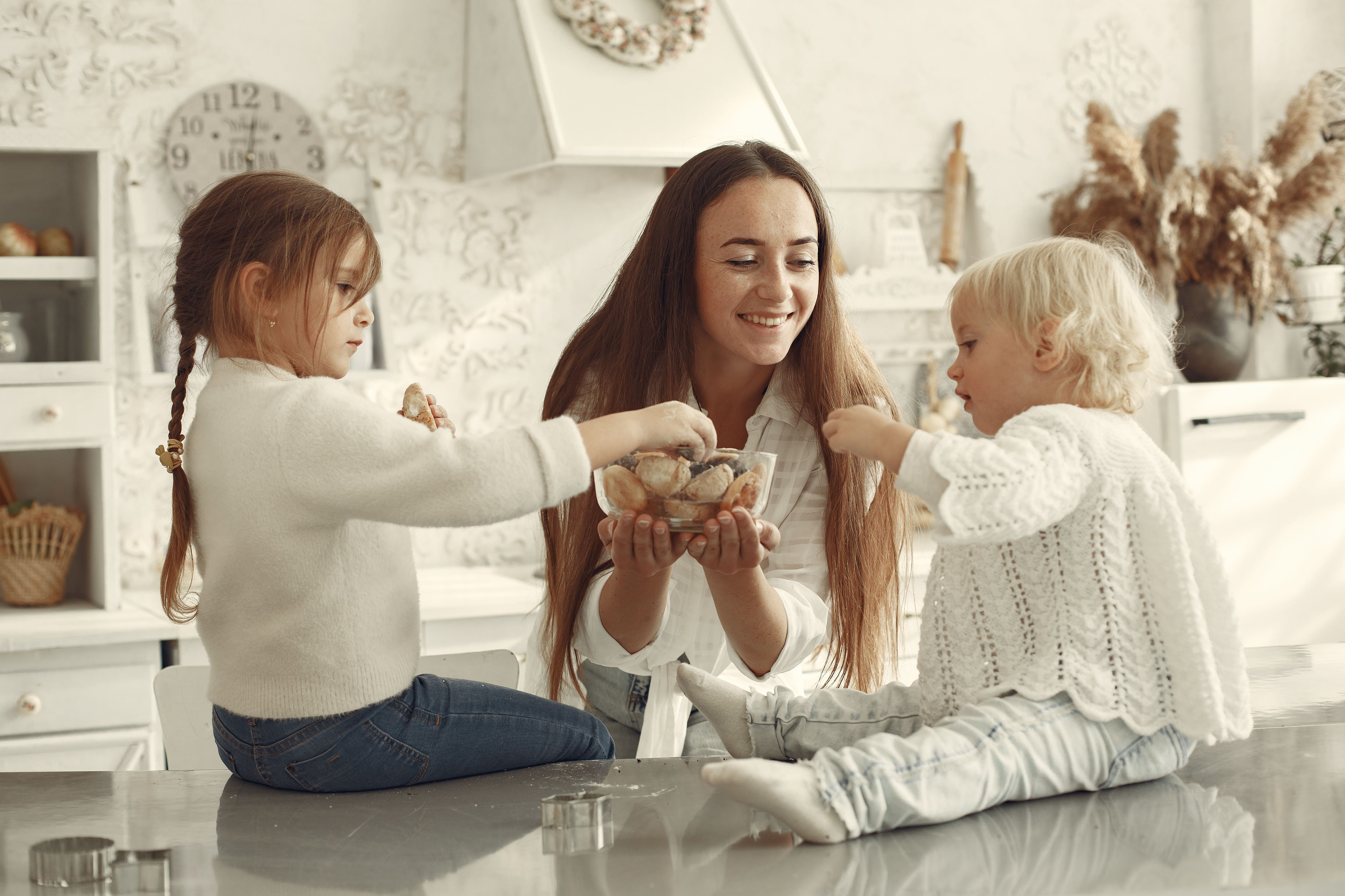 Mother enjoying a peaceful baking moment with her two young children at home, sharing food and quality family time while embracing the simple joys of motherhood. Mother enjoying a peaceful baking moment with her two young children at home, sharing food and quality family time while embracing the simple joys of motherhood.