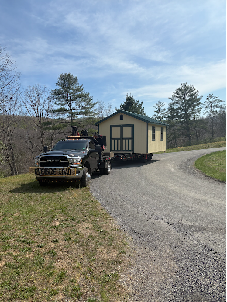 Truck transporting a shed on a specialized trailer