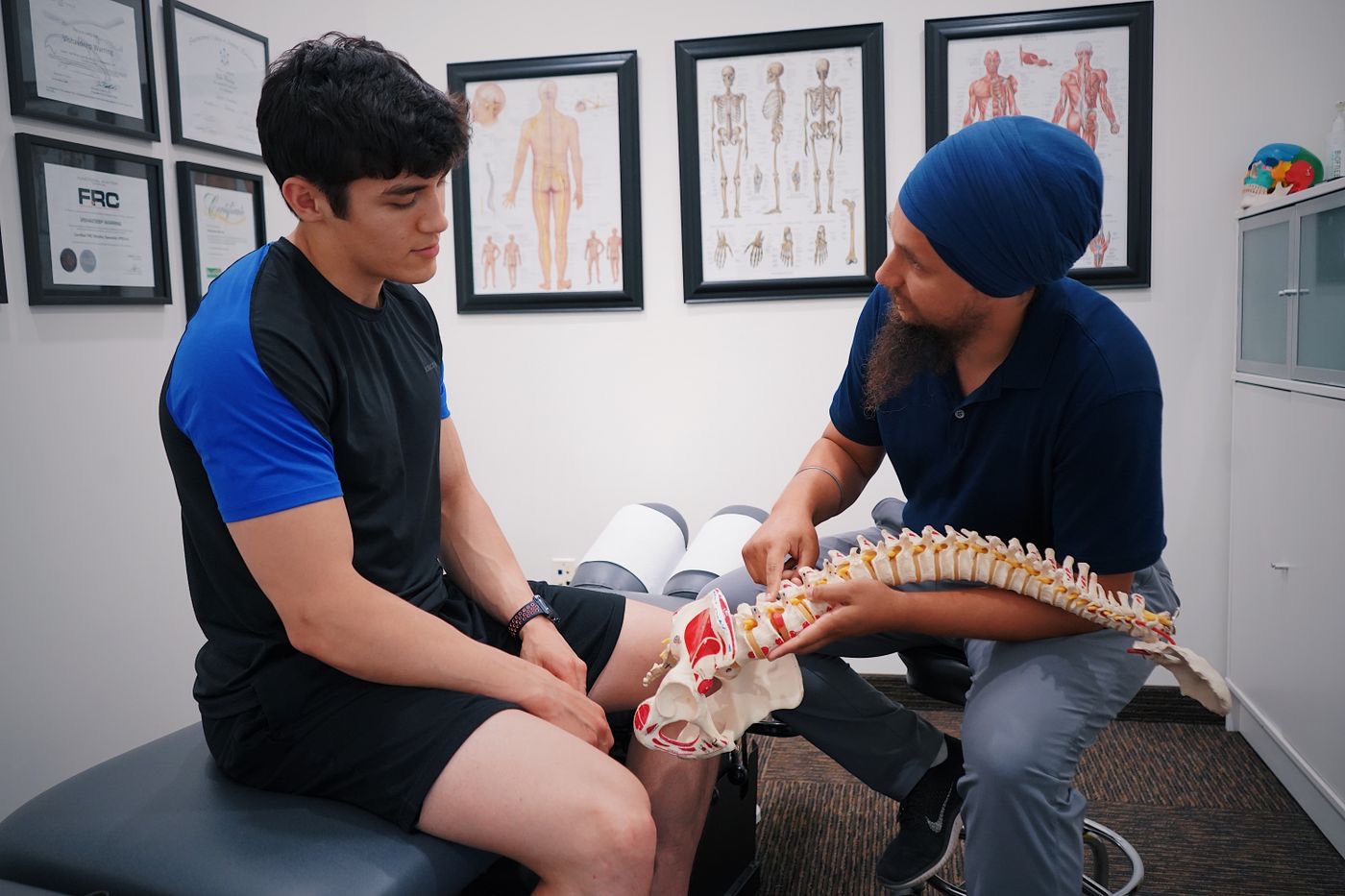 Physiotherapist explaining the spine to a patient