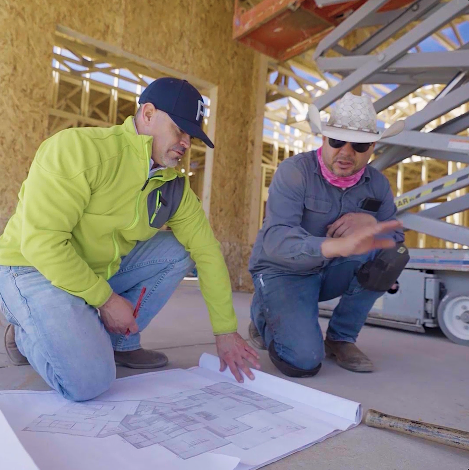 Reviewing blueprints on site inside a framed build