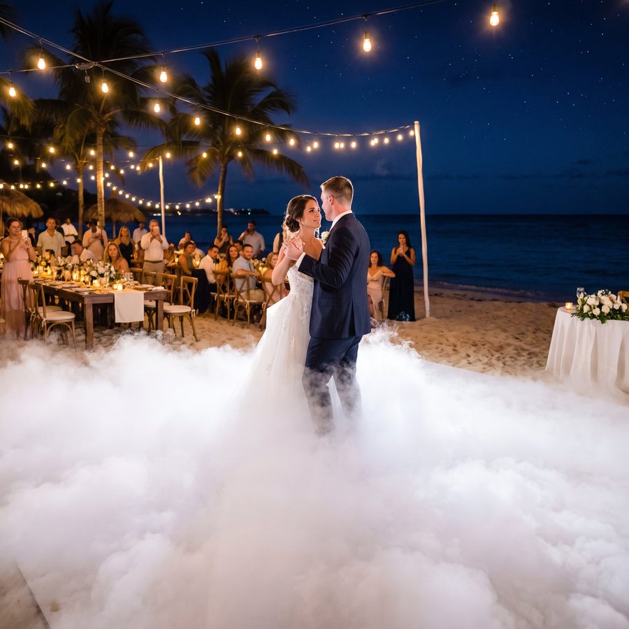A couple dancing on low fog at a beach reception
