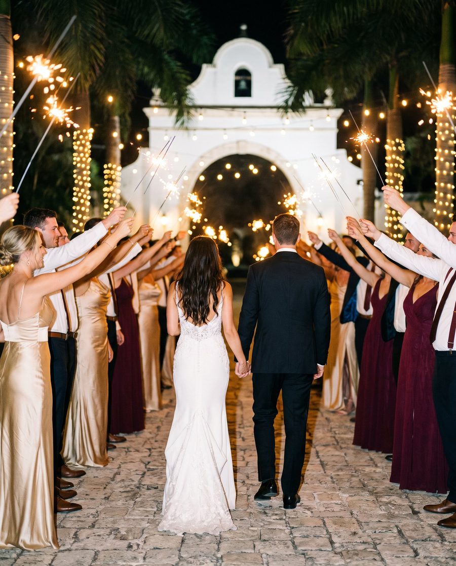 Guests raising sparklers as a couple walks out