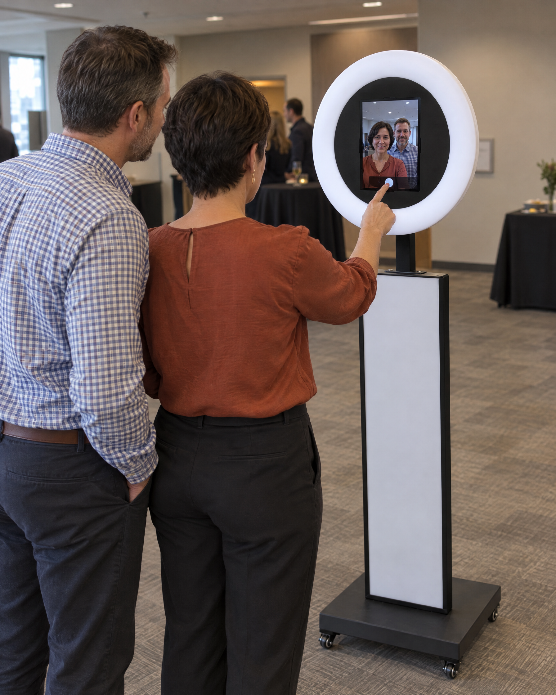 AI event mockup of fictional adult colleagues in front of the Mobile Booth, using its active touchscreen.
