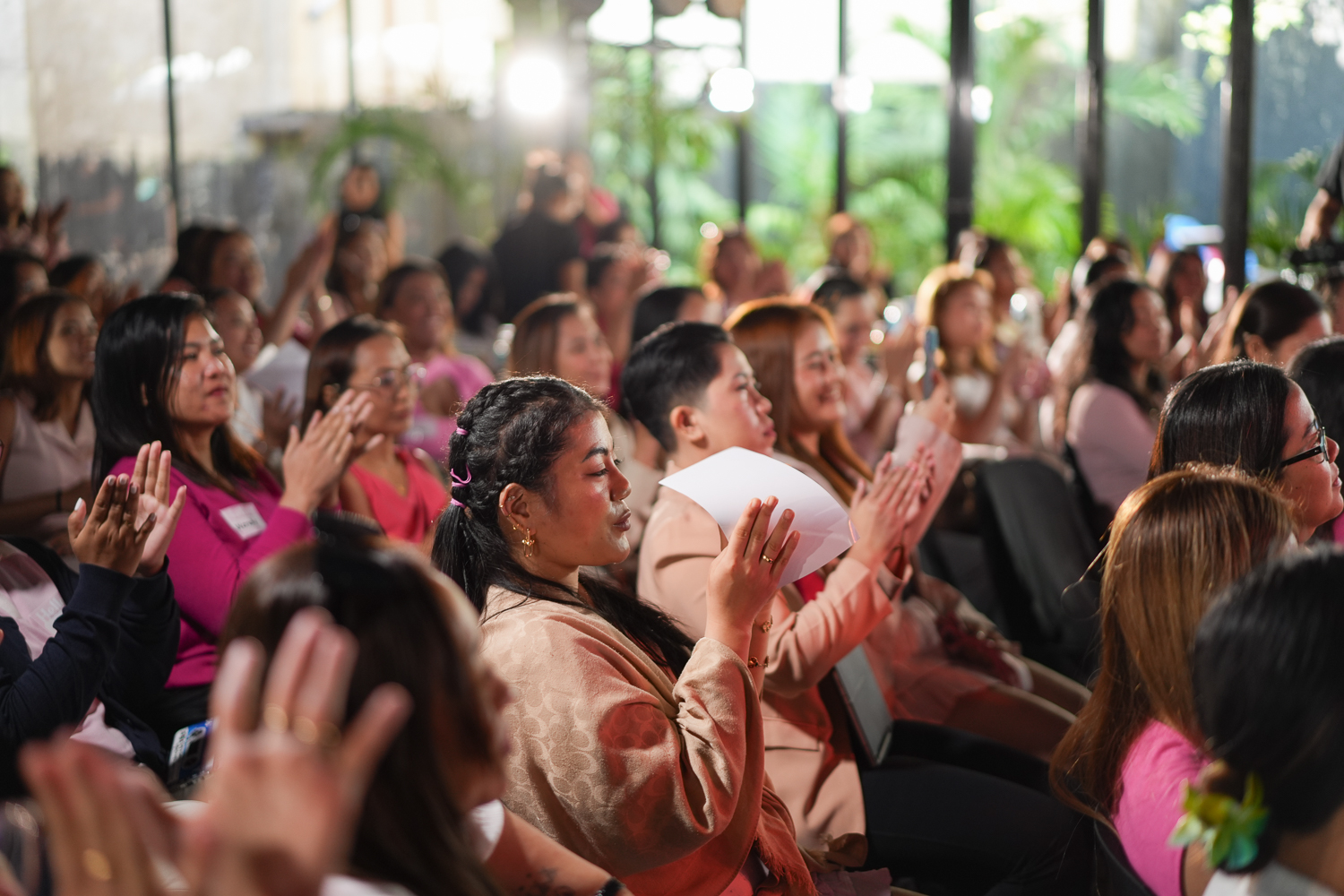 A wide row of attendees clapping in the seated room at Becoming Her Live