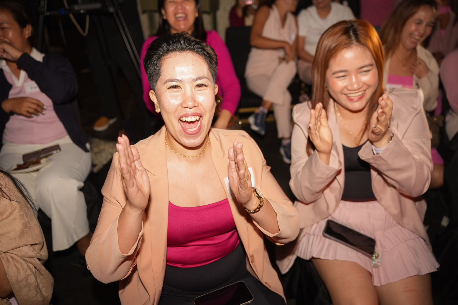 An attendee laughing and clapping mid-session at Becoming Her Live