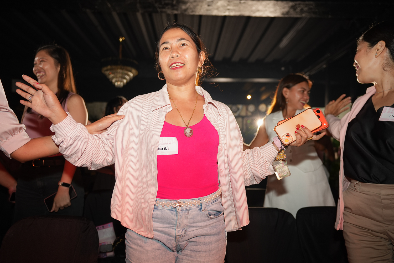 An attendee standing with her arms open among the group