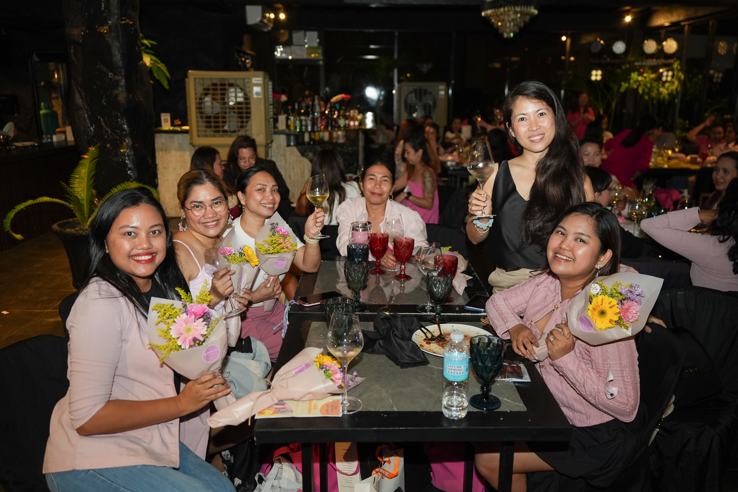 Attendees at a table with flowers and drinks at the close