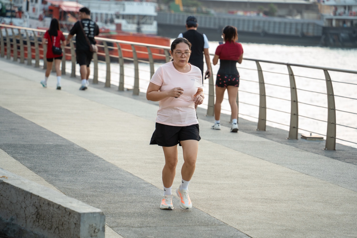 A member running alone on the waterfront promenade