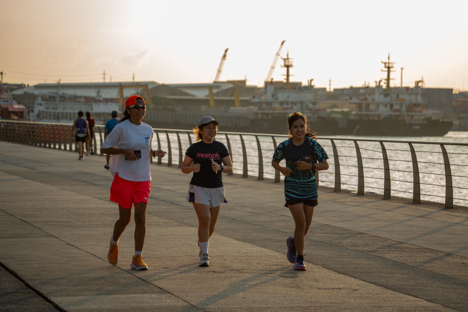 Three members running together beside the water