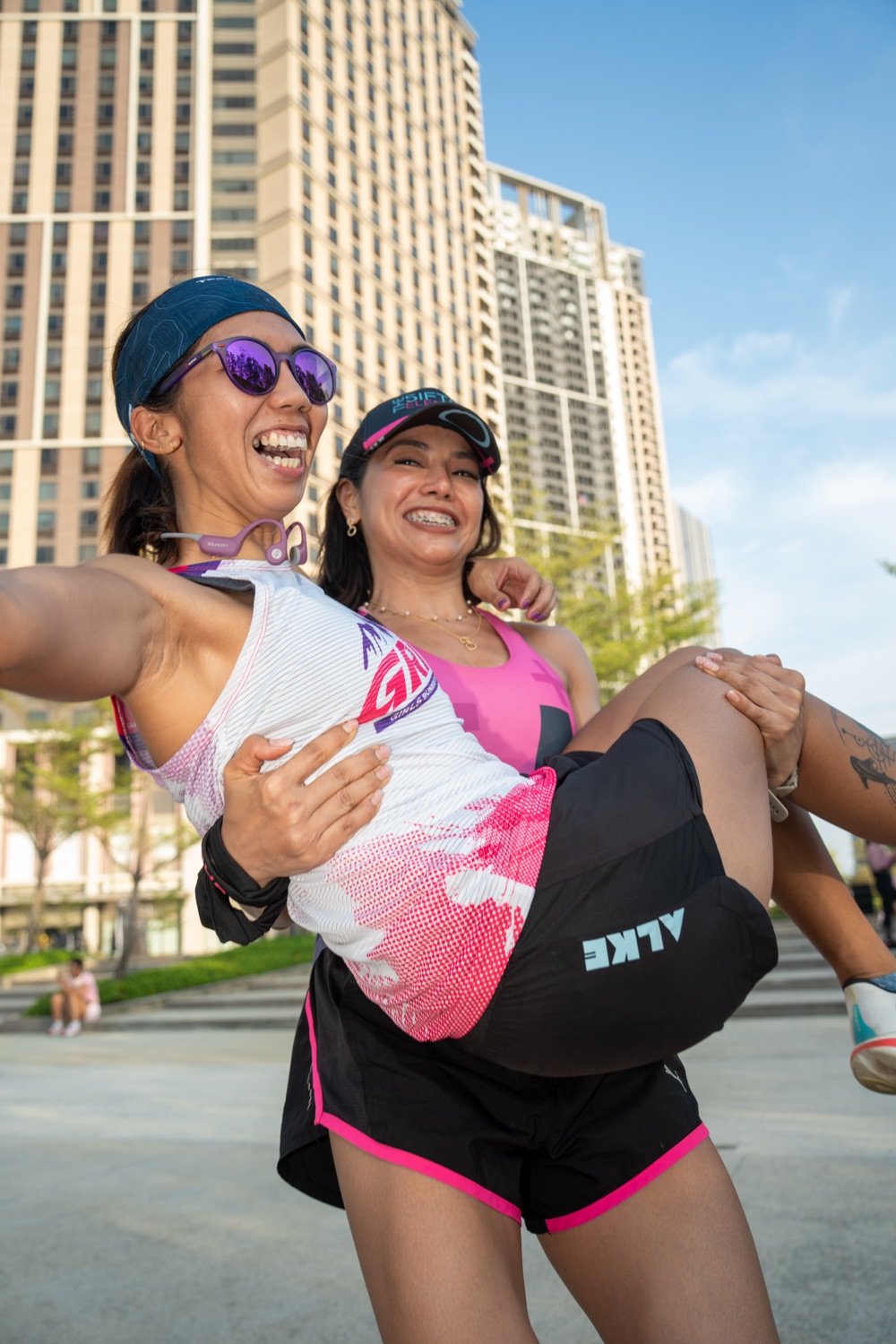 A Run Club member lifting another off the ground, both laughing