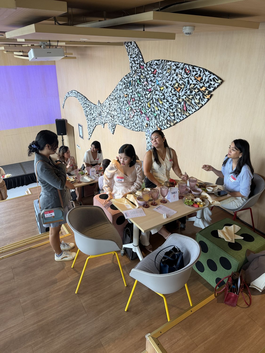A table of women talking under the mural