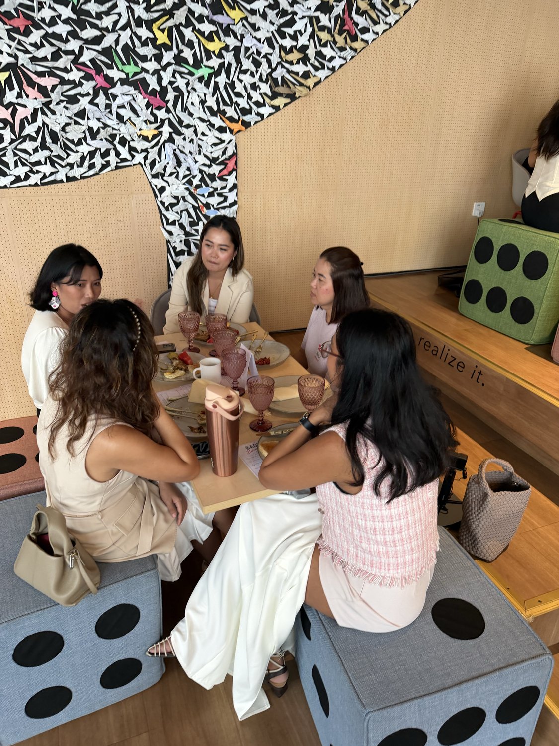 Women talking at a table with dice-shaped seats