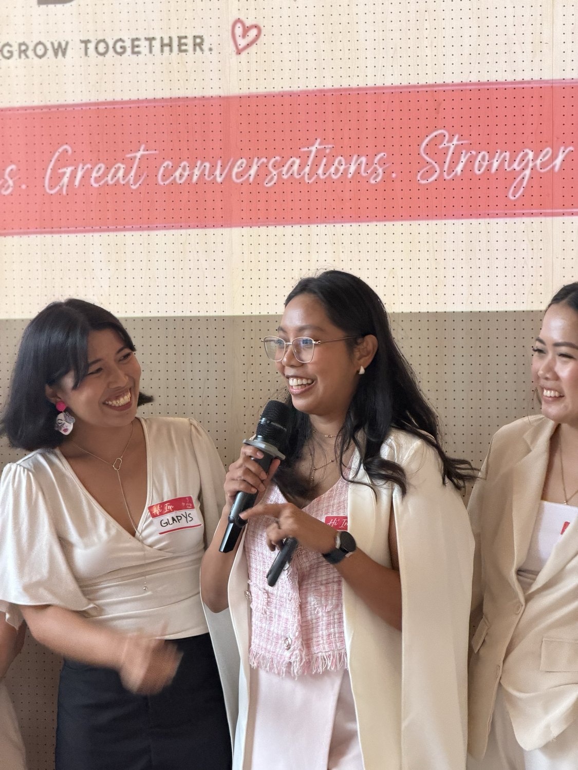 A guest laughing as she shares on the microphone
