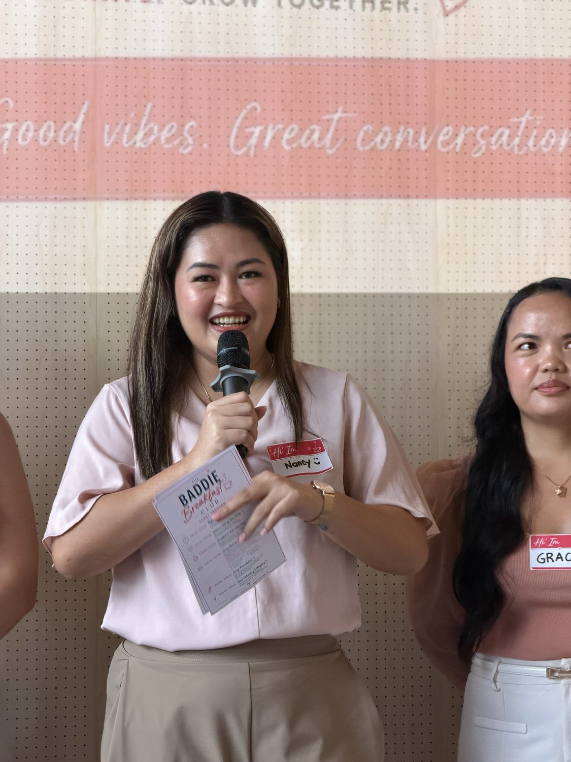 A guest smiling as she speaks into the microphone