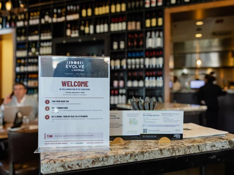 The welcome counter with a printed WELCOME sign and rows of place cards laid out.