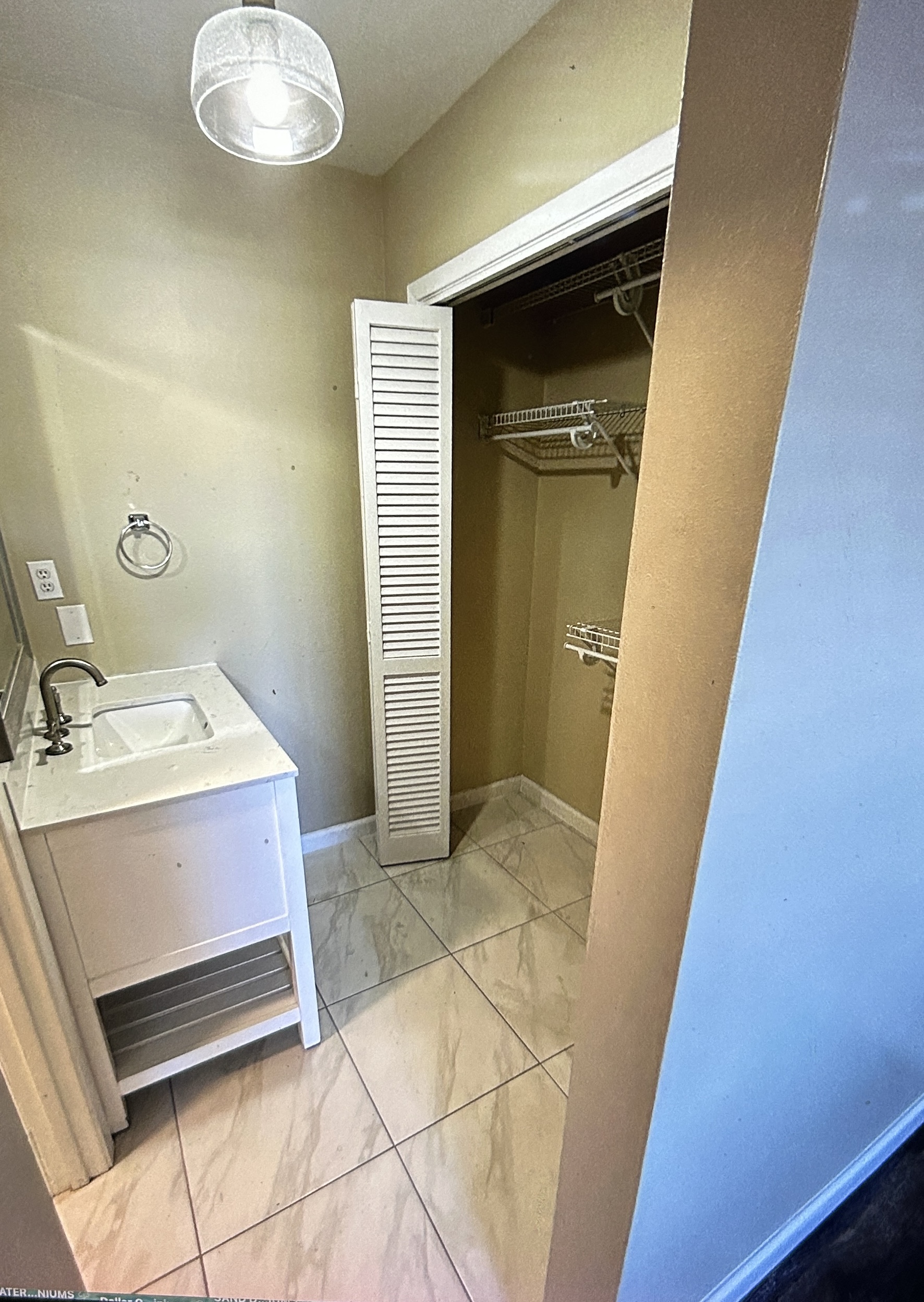 Second bathroom vanity beside a linen closet