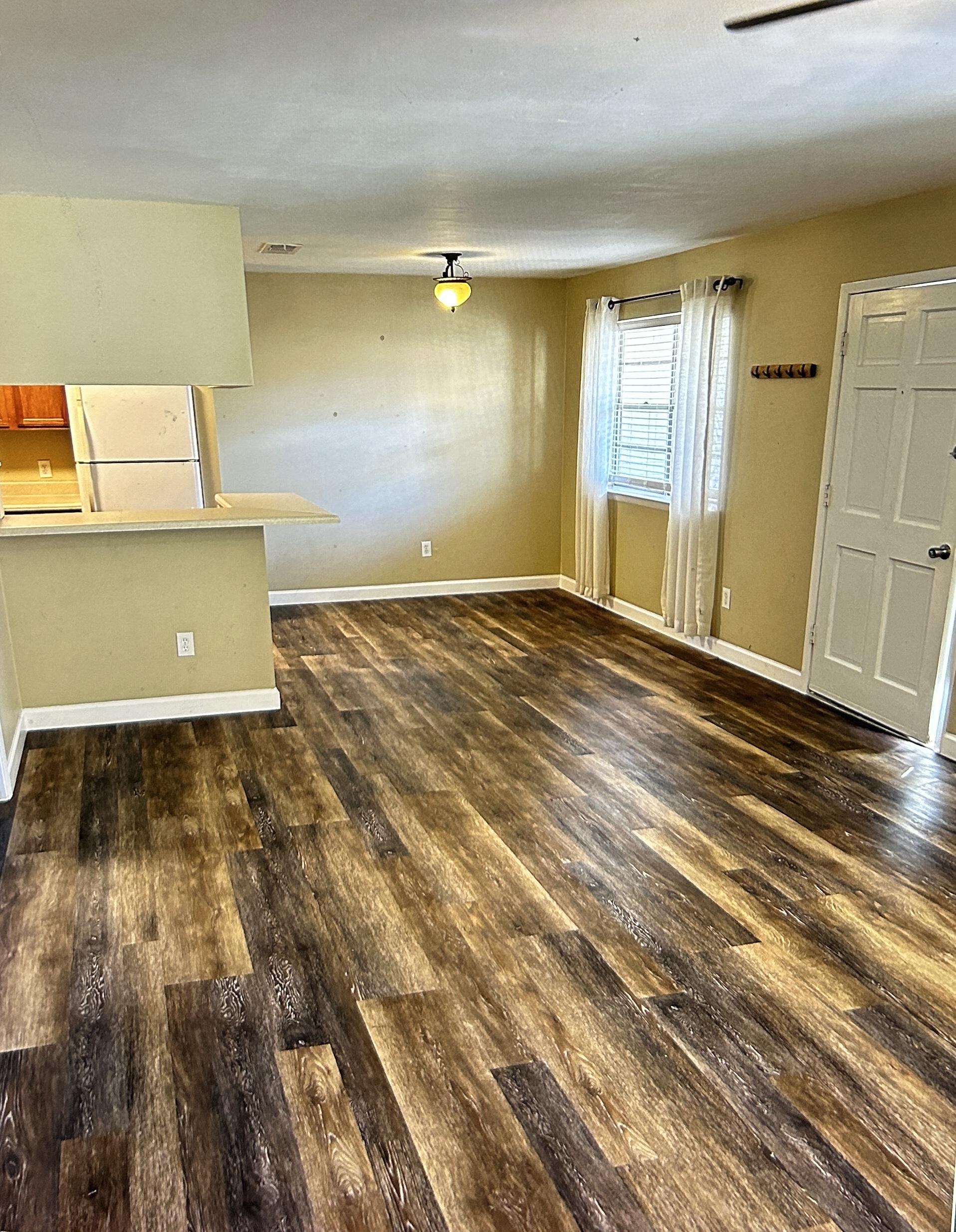 Bright living room with wood-style plank flooring and a window