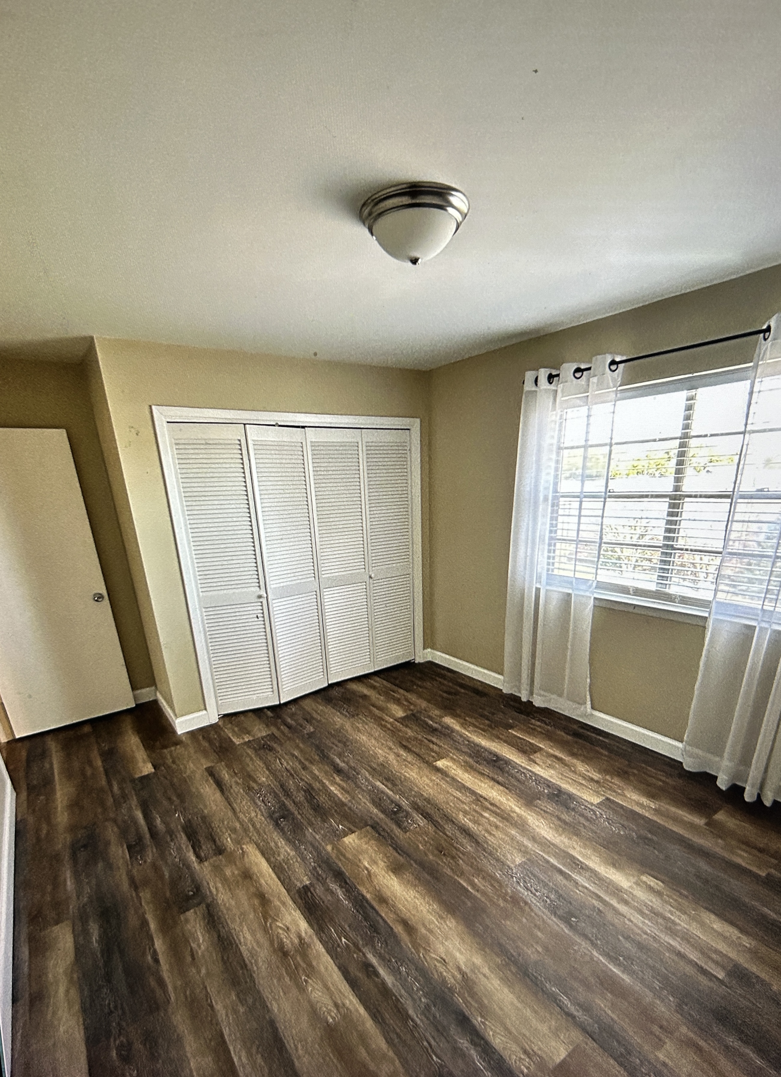 Bedroom with louvered closet doors and a window