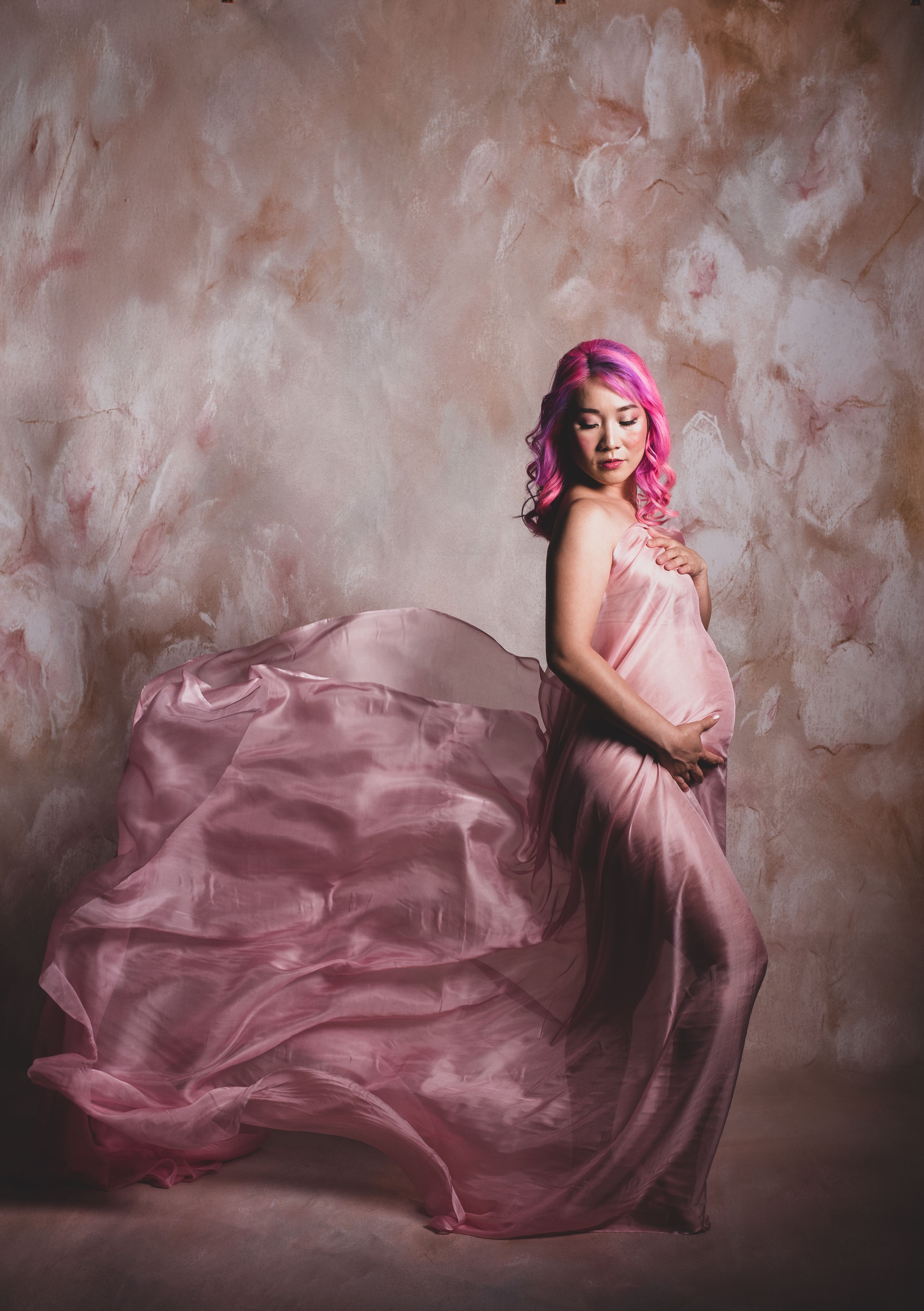 Atlanta maternity photographer captures expecting mother in dramatic fabric toss portrait with flowing gown