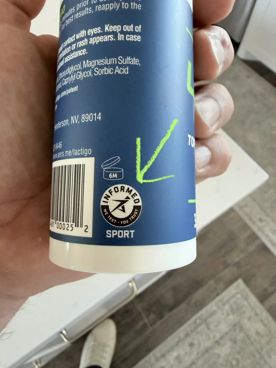 Informed Sport logo on the back of a LactiGo bottle, highlighted with a green arrow