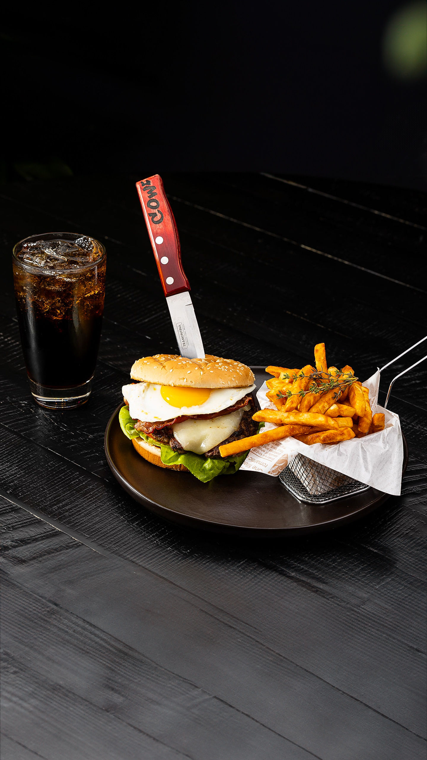 House burger with a fried egg and fries at Cow Steakhouse