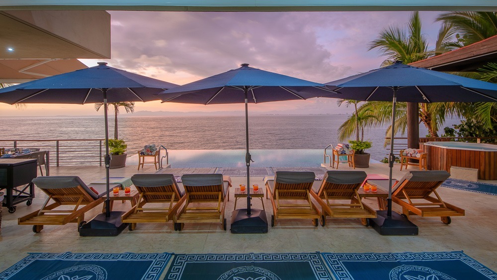 Pool reflection with symmetric umbrellas and bay views
