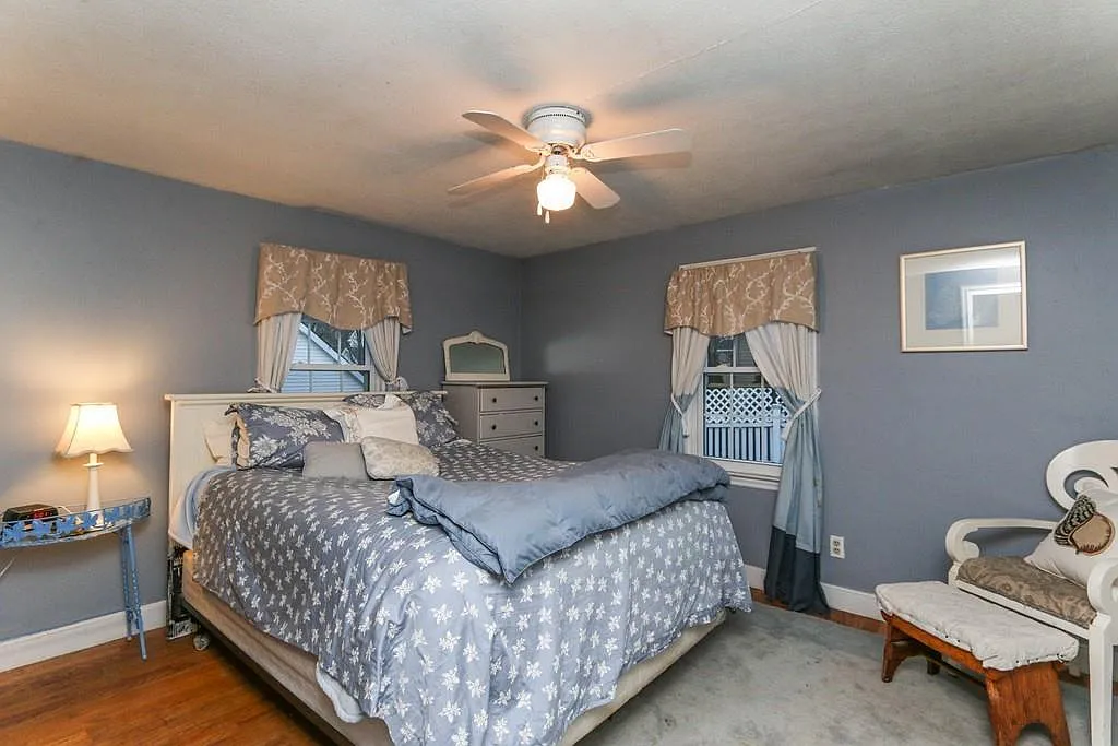 Bedroom before — dated blue walls, wall-to-wall carpet