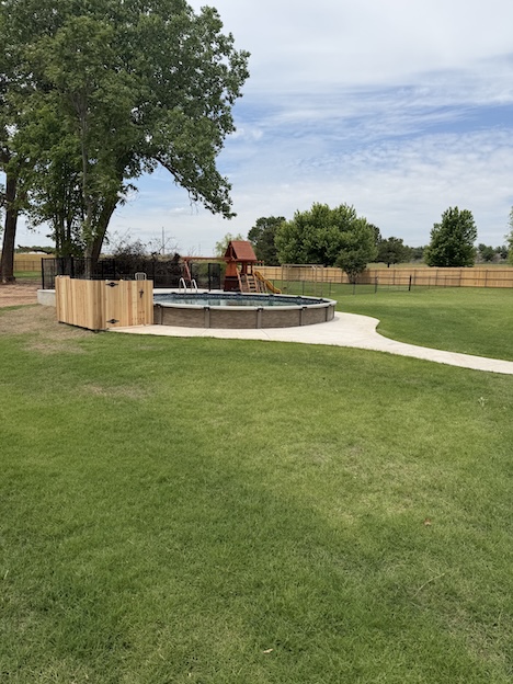 Black vinyl-coated chain link fence installation by Fence Craft Oklahoma