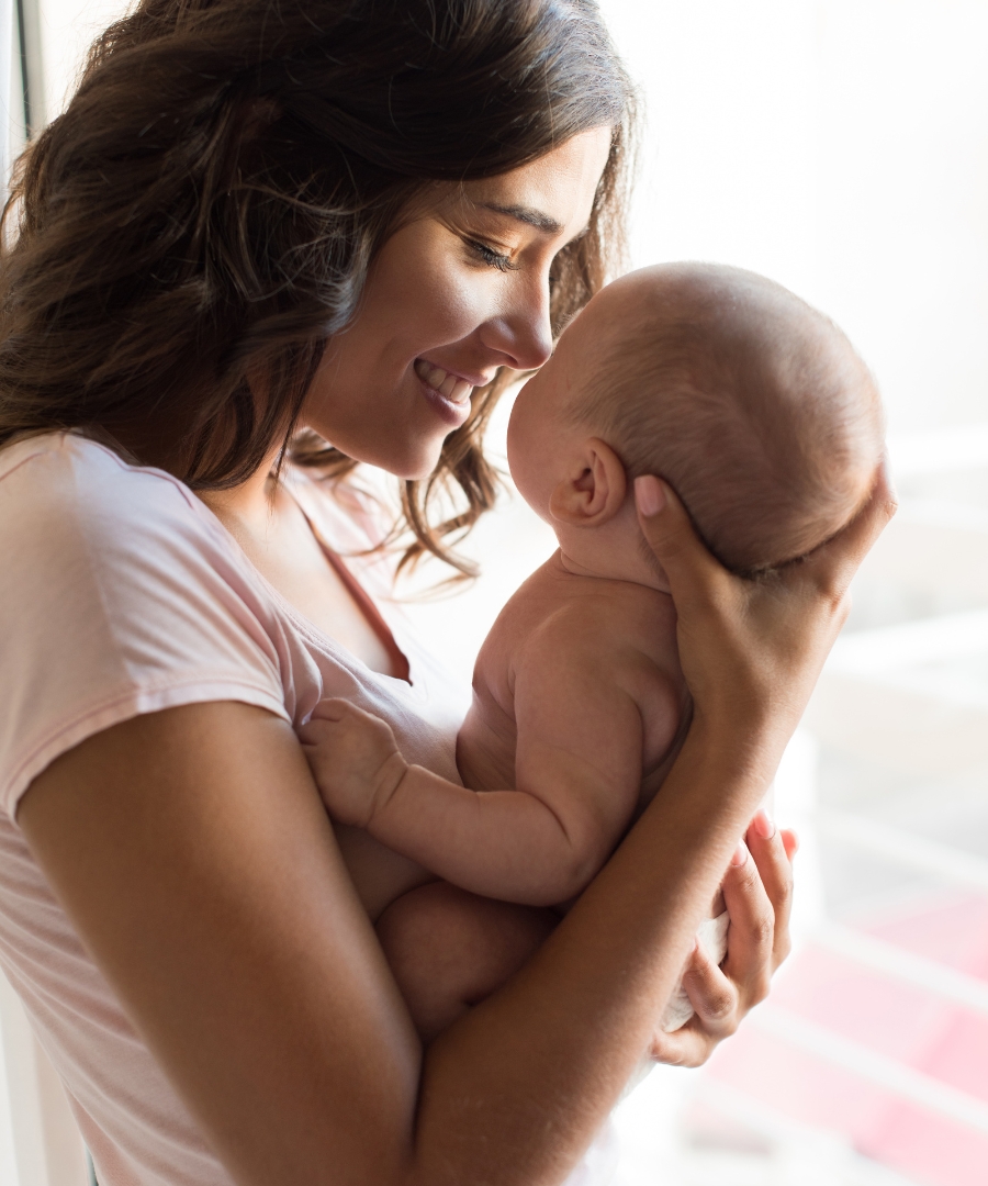 postpartum counselling for new moms a new mom holding her baby in a pink white tshirt