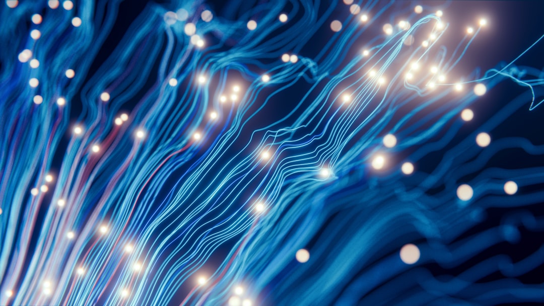 Abstract blue fibre-optic strands with glowing white points of light on a dark background.