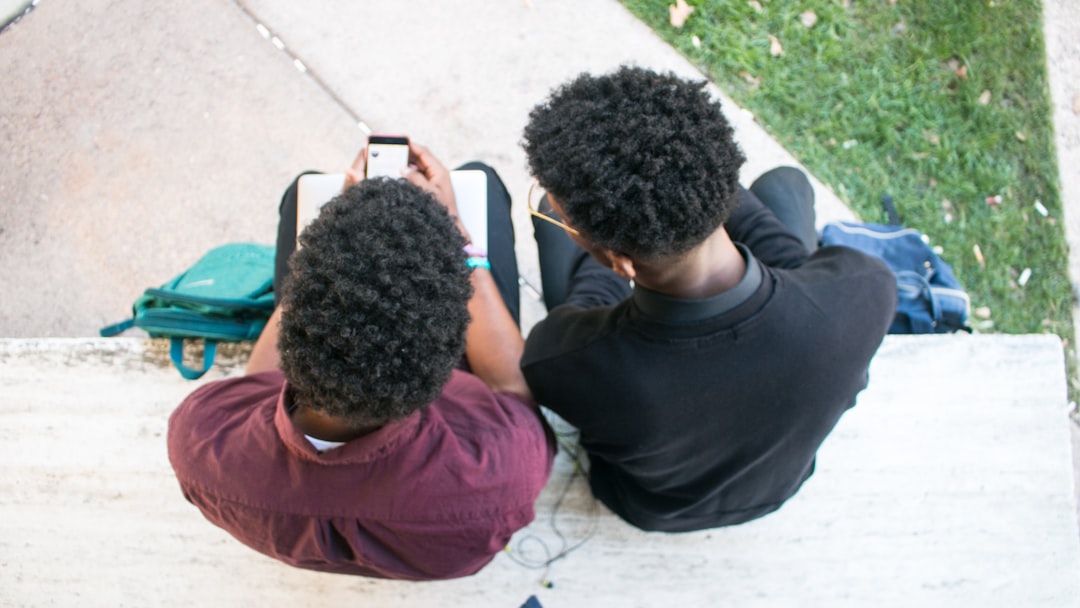 2 black youth looking at cell phone