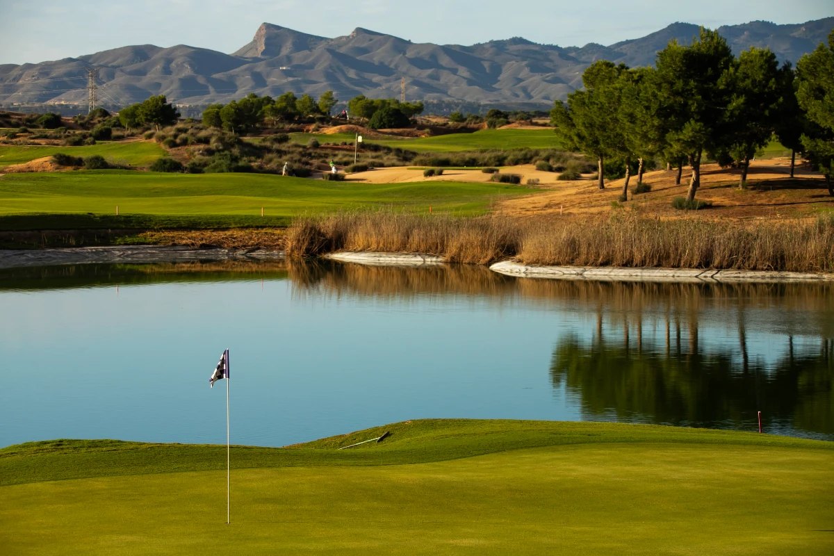 A green beside the lake at Alhama Signature Golf, with the sierra behind